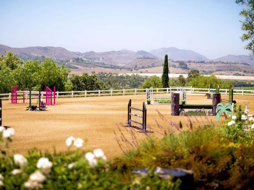 An equestrian arena with a hill in the background.